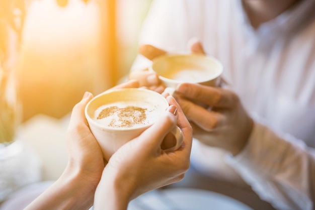 Mâle et femme tenant des tasses de boisson chaude Photo gratuit