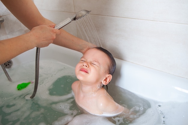 Maman Lave La Tete De Son Bebe Dans Un Bain Avec De L Eau Mousse De Shampooing Douche A Rincage Photo Premium