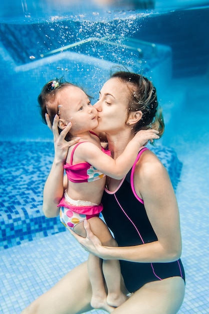 Maman Tient Sa Fille Immergee Dans L Eau Nageant Sous L Eau Dans Une Pataugeoire Plongee Bebe Apprendre A Nager Un Bebe Jeune Maman Ou Instructeur De Natation Et Heureuse Petite Fille Photo