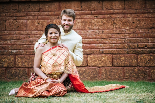 Mariée asiatique et marié caucasien ont du temps romantique avec la robe de la thaïlande Photo gratuit