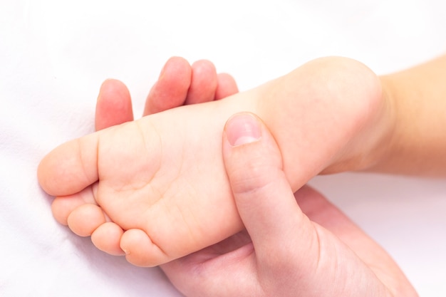 Masseur Massant Le Pied D Un Petit Enfant La Mere Fait Un Massage Sur Son Pied De Bebe Prevention Des Pieds Plats Developpement Tonus Musculaire Photo Premium