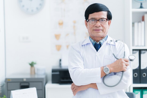 Médecin asiatique senior travaillant dans la salle d'examen Photo Premium