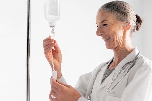 Médecin coup moyen vérifiant la perfusion Photo gratuit