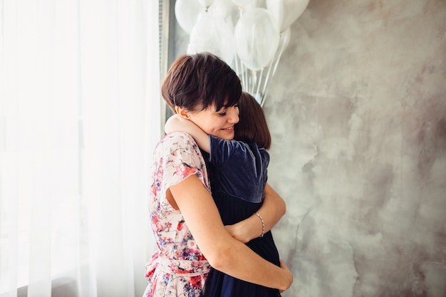 La mère embrasse sa fille dans la chambre Photo gratuit