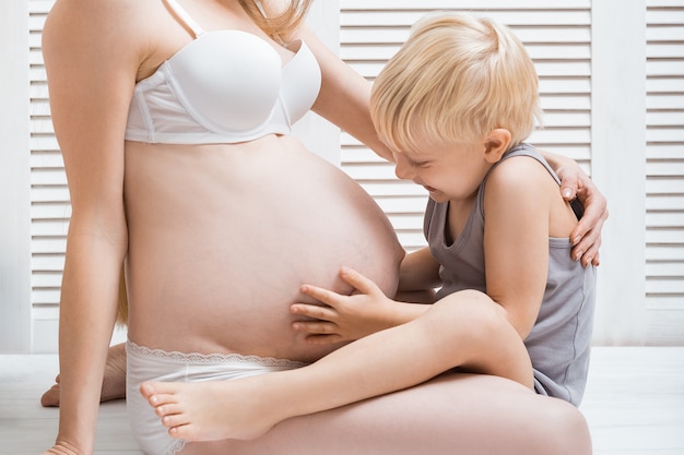 La Mere De La Femme Enceinte Et Le Bebe Sont Enlaces Garcon Mignon Touchant Le Ventre De Maman Photo Premium