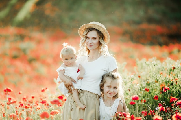 La Mere Garde Son Bebe Et Serre Sa Fille Ainee Dans Les Champs De Pavot Photo Gratuite