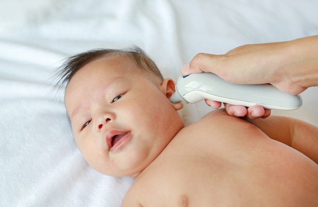 Mere Prend La Temperature Pour Bebe Avec Un Thermometre Auriculaire A La Maison Photo Premium
