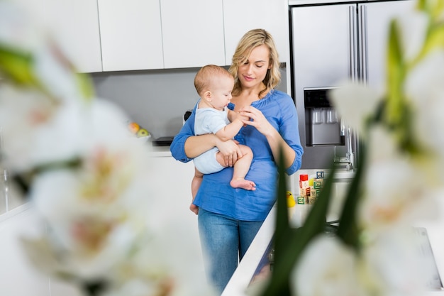 Mère Tenant Son Bébé Dans La Cuisine Photo Gratuite 