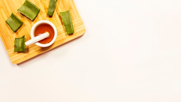 Miel et aloevera tranche sur une planche à découper en bois isolée sur fond blanc Photo gratuit