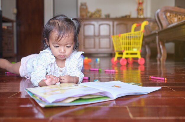 Mignon Bebe Asiatique Bebe Fille Enfant Couche Tout En Jouant Avec Des Autocollants Livre A La Maison Photo Premium