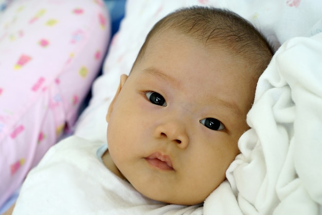 Mignon Bebe Nourrisson Asiatique En Belle Robe Couchee Et En Regardant Quelque Chose Sur Son Lit Photo Premium