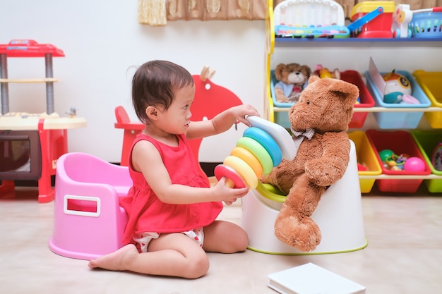 Mignon Petit Bebe Asiatique De 18 Mois Bebe Fille Enfant Assis Sur Pot Et Lire Un