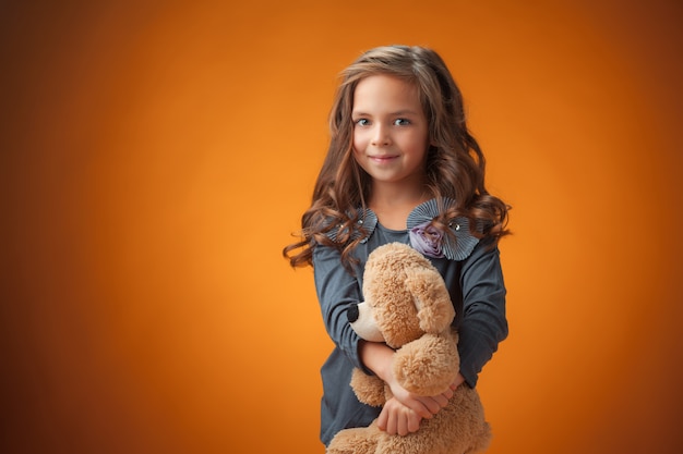 La Mignonne Petite Fille Joyeuse  Sur Le Mur Orange Photo 