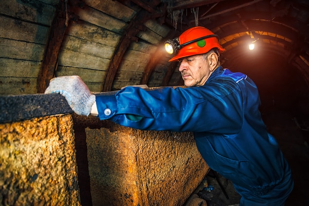 Un Mineur Dans Une Mine De Charbon Se Trouve Pres D Un Chariot Espace De Copie Photo Premium