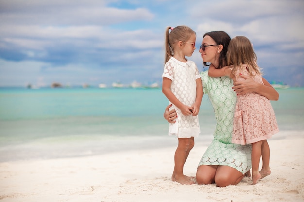 Mode mère et ses deux filles adorables à la plage exotique sur une journée ensoleillée Photo Premium