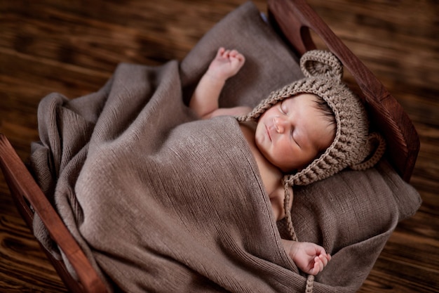 Nouveau Ne Beau Nourrisson Se Trouve Dans Une Couverture De Fourrure Brune Sur Fond De Bois Fille De 10 Jours Dormant Dans Le Lit Copiez L Espace Photo Premium