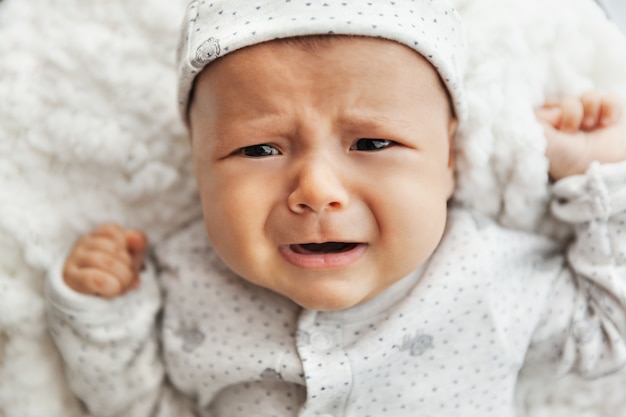 Nouveau Ne Pleurer Bebe Fille Portant Sur Une Couverture Blanche Nourrisson Fatigue Et Endormi En Pijamas Photo Premium