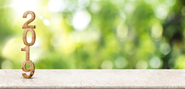 Nouvel an 2019 sur une table en marbre au flou bokeh vert abstrait avec fond de rayon de soleil Photo Premium