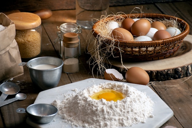 Oeufs, pâte et farine sur une table en bois avec fond de splat pour un objet dans une boulangerie Photo Premium