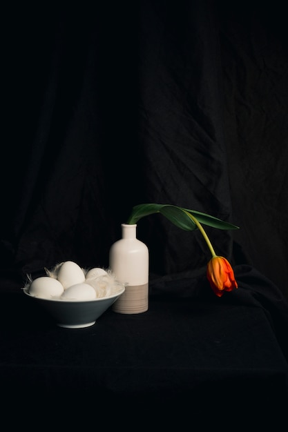 œufs Et Plumes Près Dune Fleur Doranger Fanée Dans Un Vase