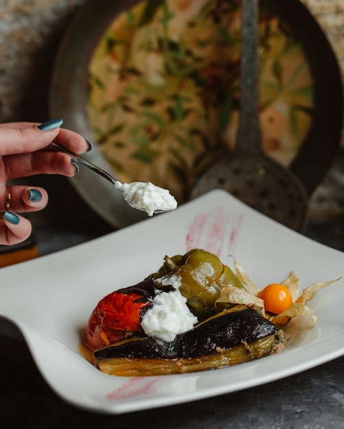 Olma de légume traditionnel dans une assiette blanche avec du yaourt Photo gratuit