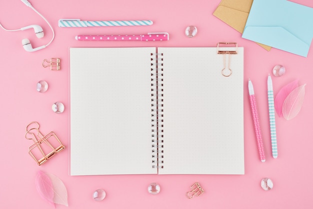 Page de bloc-notes vierge dans le journal de balle sur le bureau rose vif. vue de dessus de la table lumineuse moderne Photo Premium