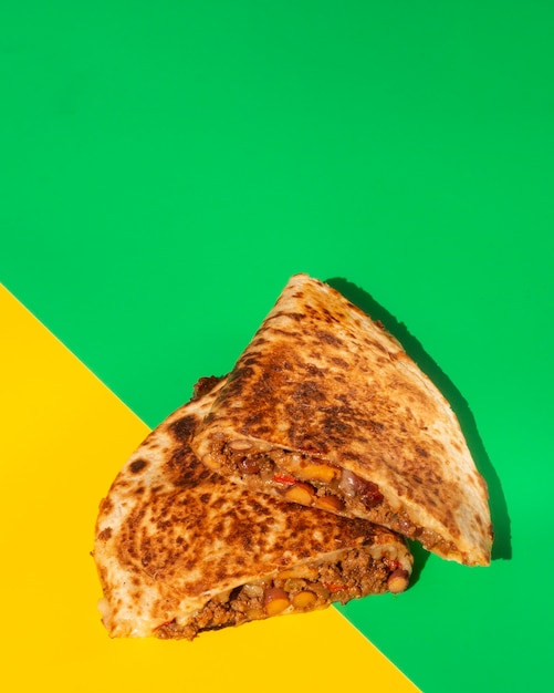 Pain croustillant de tortilla plat poser sur fond vert et jaune Photo gratuit
