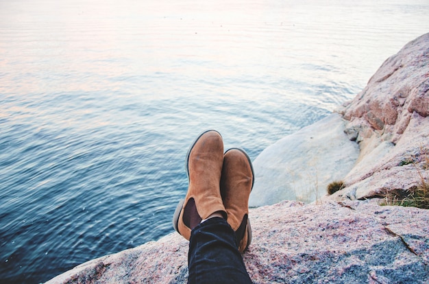 Une paire de bottes reposant sur une montagne face à la mer Photo gratuit