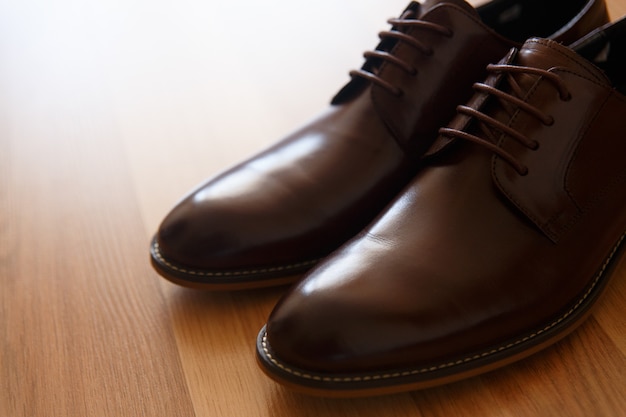Une paire de chaussures en cuir marron sur un plancher en bois Photo Premium