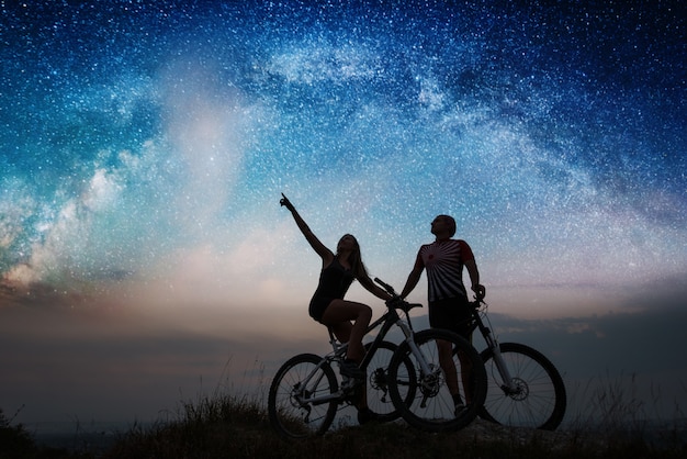 Paire Avec Des Vélos De Montagne Sous Ciel étoilé De Nuit