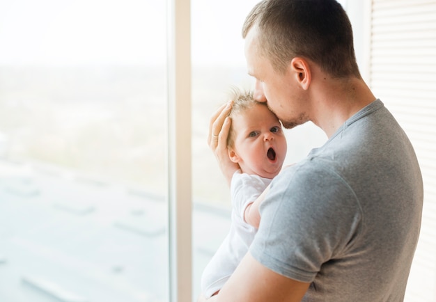 Papa Embrasse Bebe Avec La Bouche Ouverte Dans Le Front Photo Gratuite