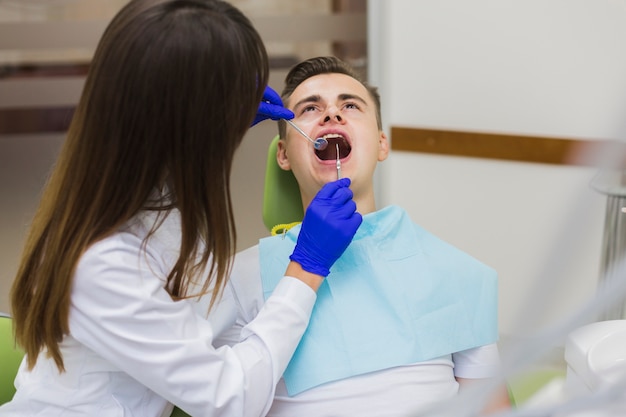 Patient faisant vérifier ses dents par un dentiste Photo gratuit
