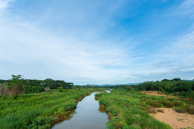 Paysage avec terrain gazonné, rivière petite le soir. Photo Premium