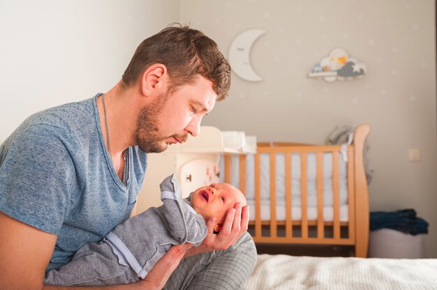 Pere Et Nouveau Ne A L Interieur De La Chambre Scandi Le Pere Chante Une Berceuse A L Enfant Le Parent Calme Le Bebe Avant D Aller Se Coucher Dans Ses Bras Photo Premium