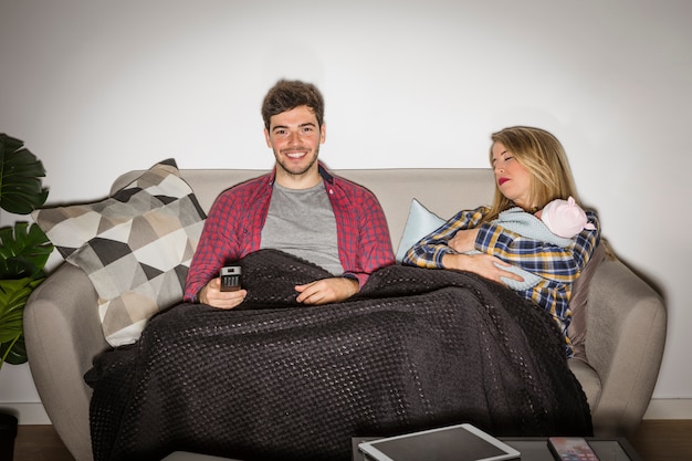 Pere Regarde La Television Pendant Que La Mere Avec Bebe Dort Photo Gratuite