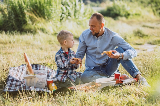 Père avec son fils pique-nique dans le parc Photo gratuit