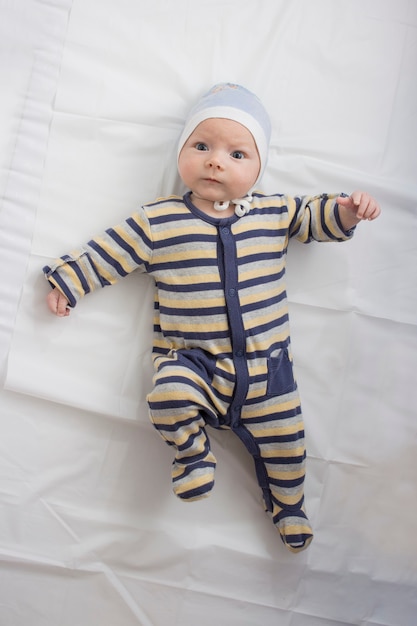 Petit Bebe Dans Des Vetements Avec Une Drole De Tete Sur Une Feuille Blanche Photo Premium