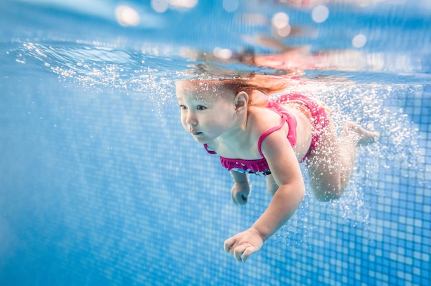 Petit Bebe Fille Nageant Sous L Eau Dans La Pataugeoire Plongee Bebe Apprendre A Nager Un Bebe Profitez De La Baignade Et Des Bulles Photo Premium