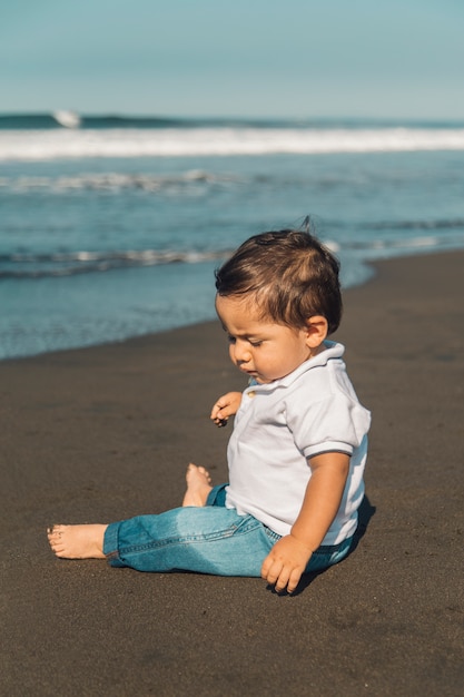 Petit Bebe Garcon Assis Sur Le Sable De La Plage Photo Gratuite