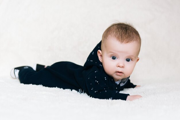 Petit Bebe Garcon Couche Et Levant La Tete Pendant Un Moment A La Surprise Et Au Sourire Mignon Nouveau Ne Photo Premium