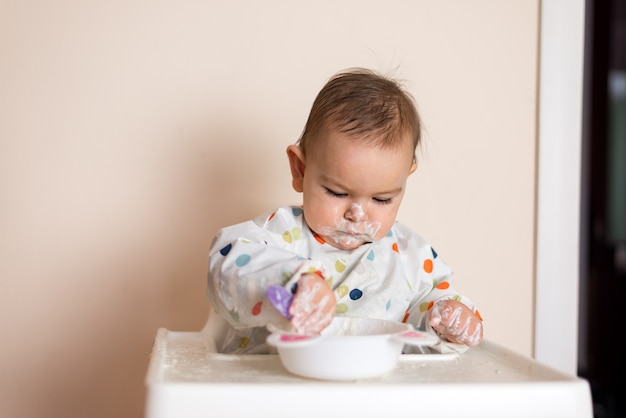 Un Petit Bebe En Train De Manger Son Diner Et De Faire Des Degats Photo Premium