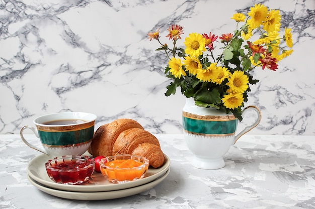 Petit Dejeuner Francais Avec Croissants Confiture D Abricot Confiture De Cerise Et Une Tasse De The Fleurs Rouges Et Jaunes Photo Gratuite