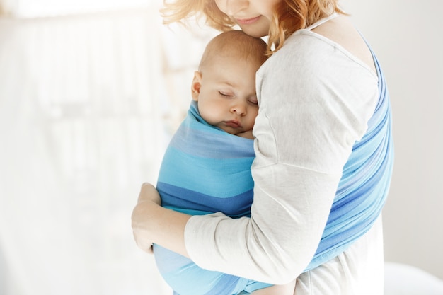 Petit Enfant Nouveau Ne Ferme Les Yeux Et Dort Bien Dans Le Porte Bebe Se Sentant Protege De Sa Belle Jeune Mere Famille Concept De Style De Vie Photo Gratuite