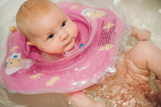 Un Petit Enfant Se Lave La Tete Dans La Baignoire Une Petite Fille Est Allongee Dans La Salle De Bain Avec Un Cercle Photo Premium