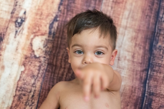 Petit Garcon Aux Yeux Bleus Allonge Sur Un Mur En Bois Photo Gratuite