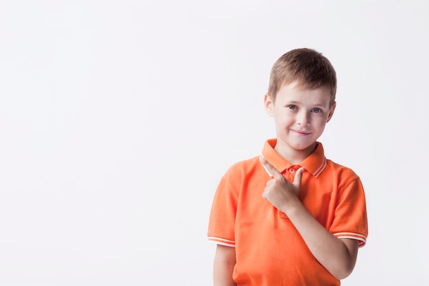 Petit garçon mignon gesticulant et regardant la caméra Photo gratuit
