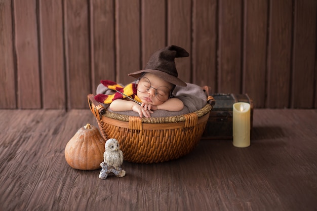 Petit garçon portant à l'intérieur d'un petit panier avec un costume de sorcier drôle Photo gratuit