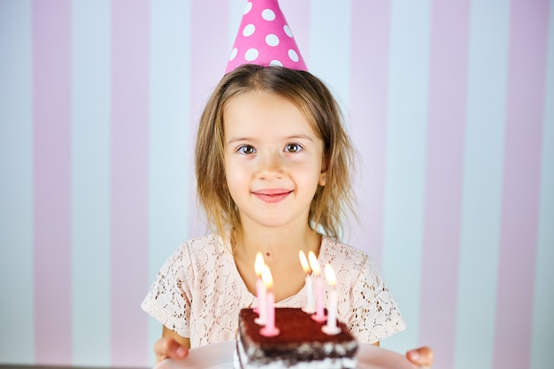 Petite Fille Blonde Souriante Au Chapeau Rose D Anniversaire Un Gateau D Anniversaire Au Chocolat Avec Des Bougies L Enfant Fete Son Anniversaire Bon Anniversaire Photo Premium