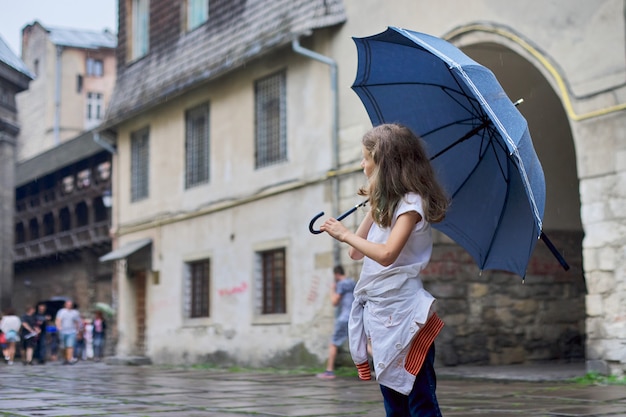 Petite Fille Enfant Sous La Pluie Avec Un Parapluie Vieille Ville Touristique Photo Premium