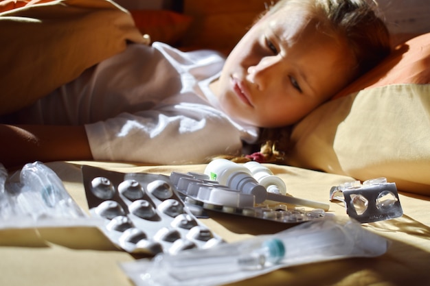 Petite Fille Malade Au Lit Avec Des Medicaments Rhumes Saisonniers Chez Les Enfants Maladies Des Enfants Traitement A Domicile Pour Un Enfant Bebe Et Pilules Photo Premium